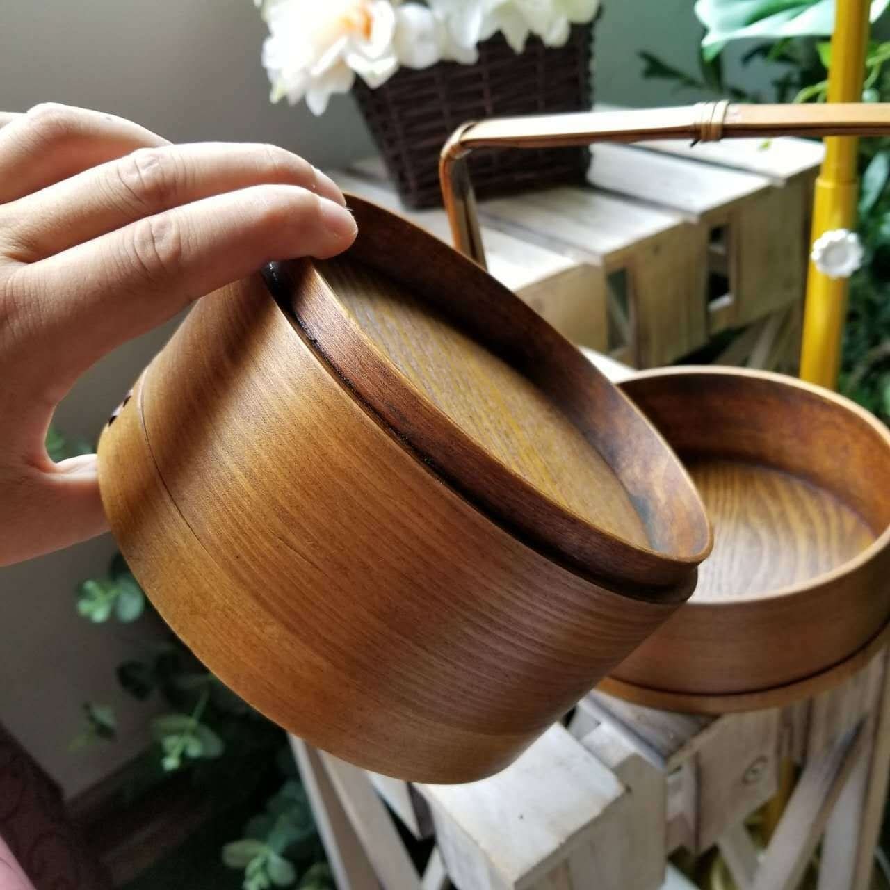 Wooden Japanese lunch box with a natural finish and intricate grain, ideal for home decor.